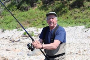 Senior gentleman wearing waders & fishing in the Long Island Sound