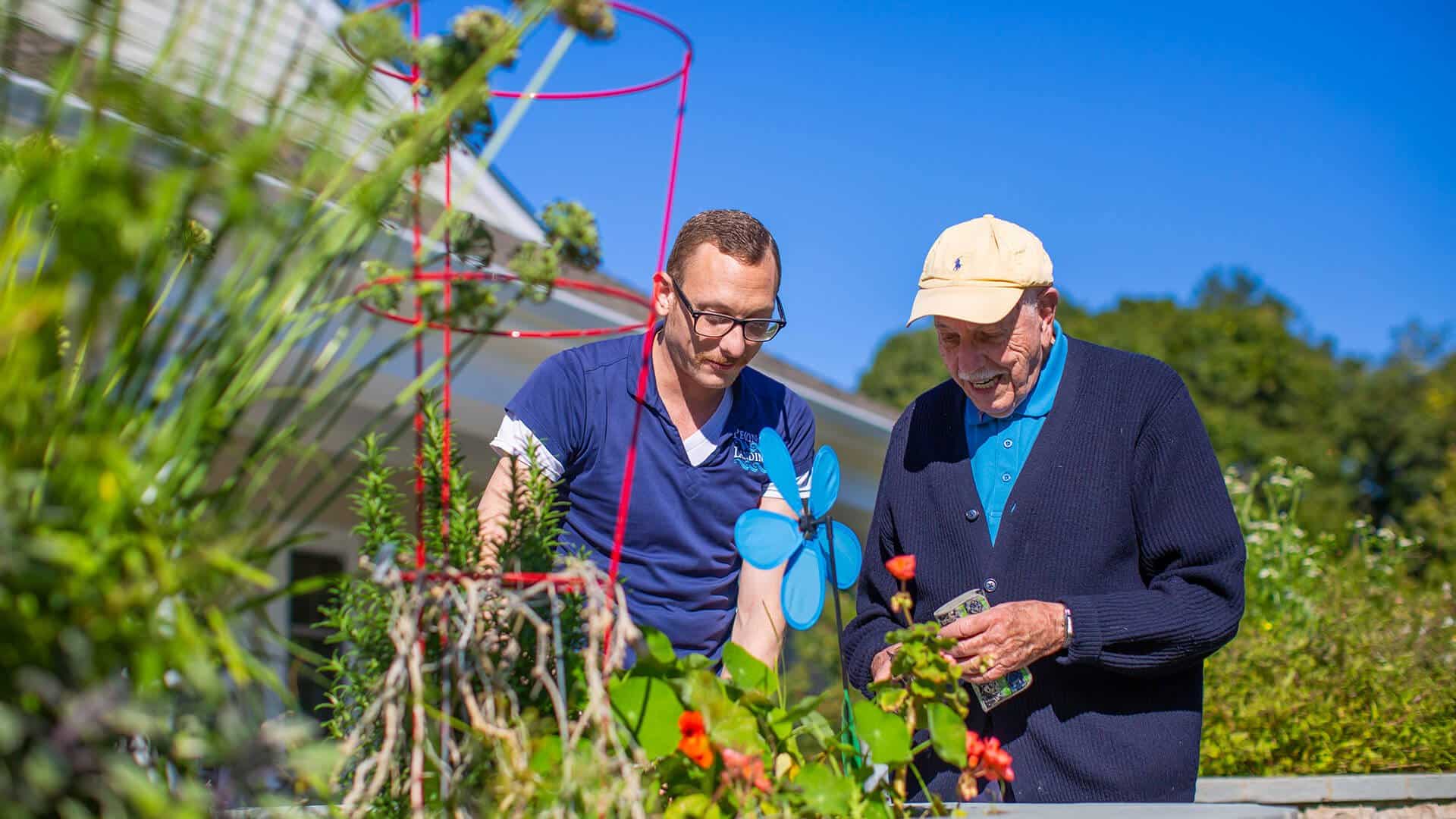 Nurse gardening w/senior man at Peconic Landing senior living facility