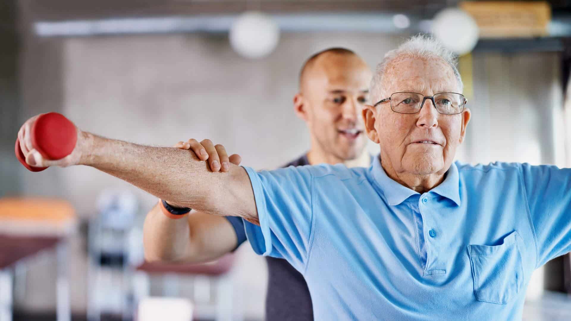 Young Physical Therapist working with a senior gentleman at Peconic's rehabilitation center